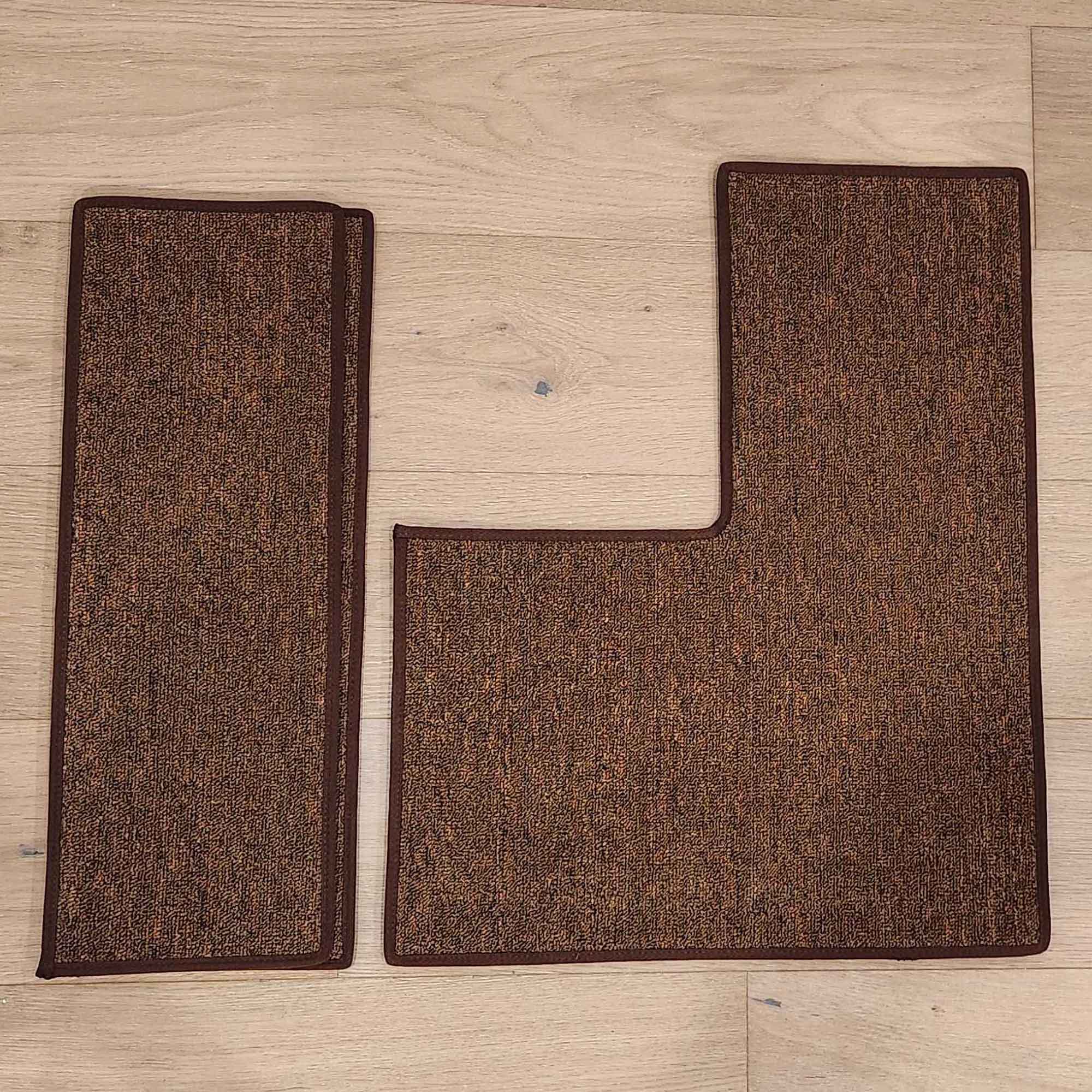 Two brown rectangular carpet mats, one with an L-shaped cutout, on a light wood floor with textured surfaces.