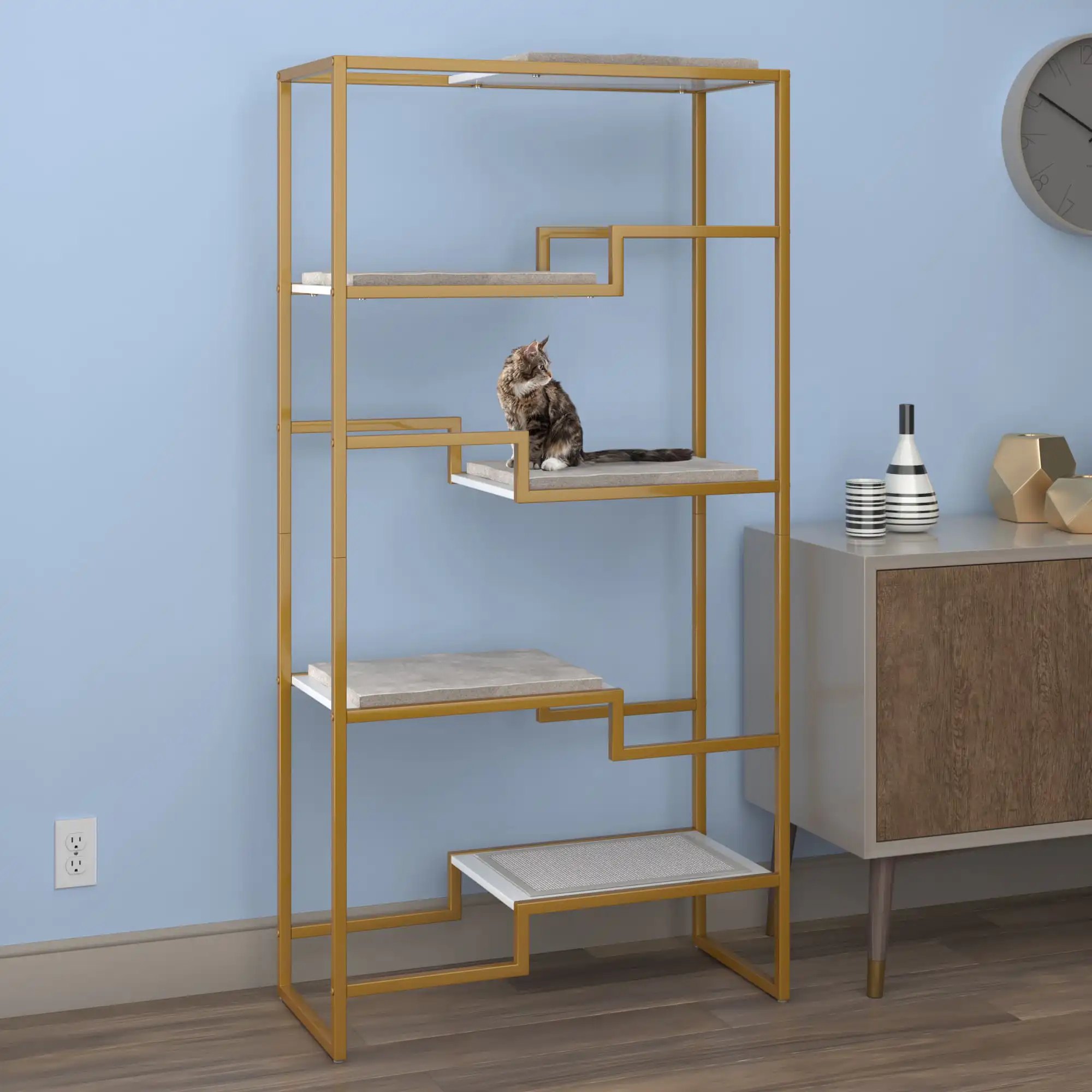 Cat on the middle platform of a gold-frame, white-platform, gray-cushion cat tree in a stylish blue-walled living room.