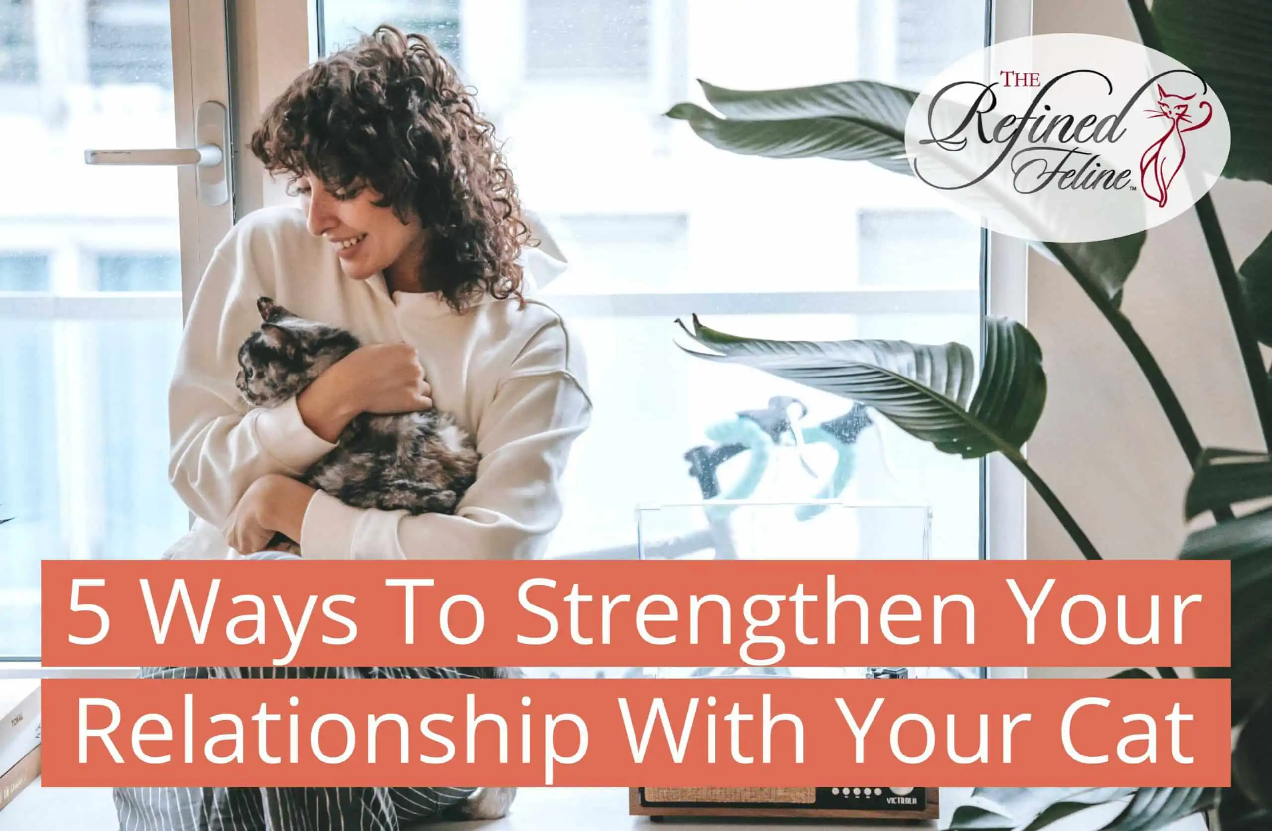Woman smiling by a window while holding her cat. Text: “Strengthen Your Relationship With Your Cat – 5 ways to build a closer bond.”.