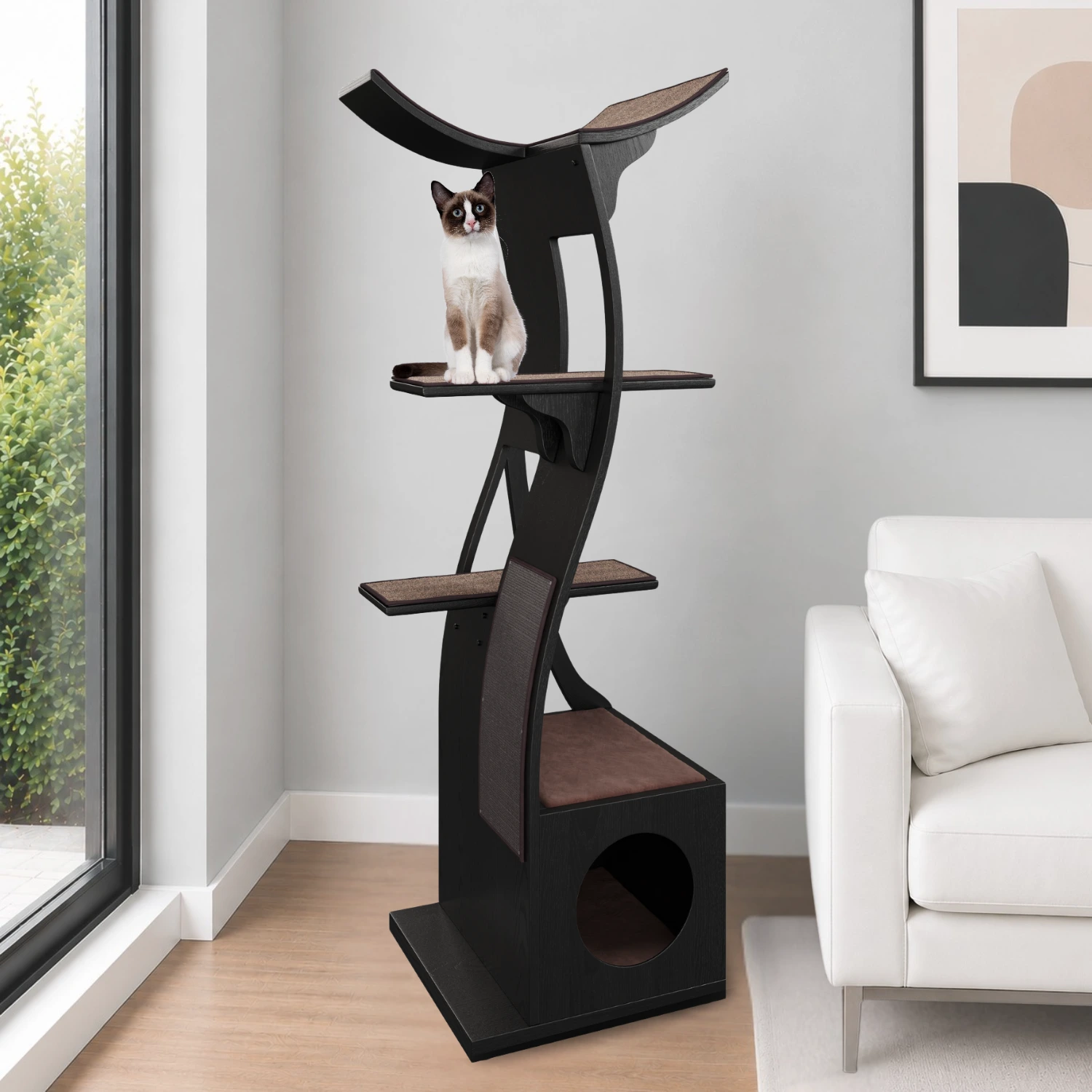 A cat sits atop the Lotus Cat Tower in a modern living room with a white sofa, abstract art, and large window.