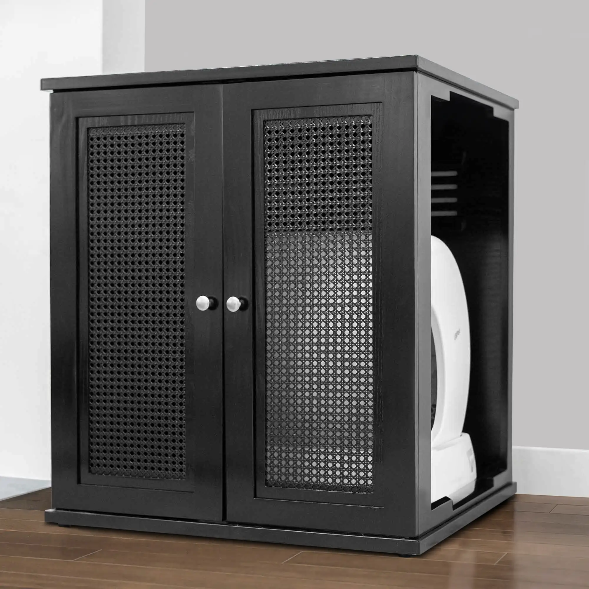 Black wooden litter box cabinet with mesh doors on a wooden floor, against a gray wall, concealing self-cleaning box.